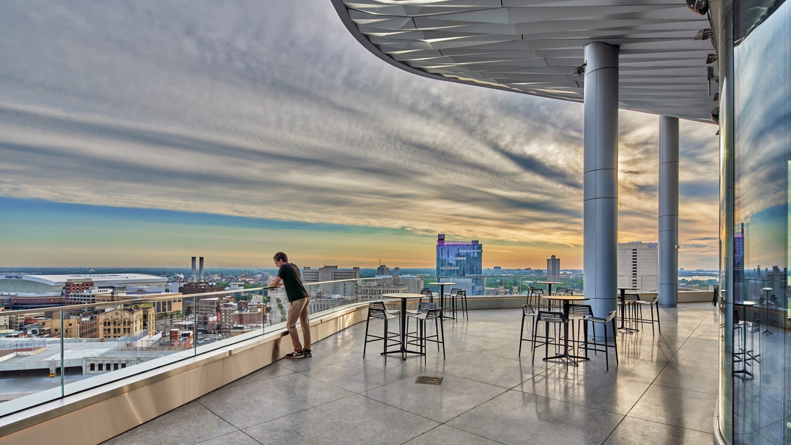 Man on the terrace of Elevate at One Campus Martius, overlooking the city of Detroit.